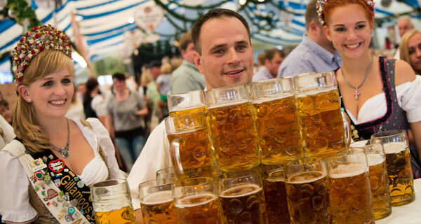 Oliver Strümpfel beim Weltrekordversuch im Maßkrugtragen am Gillamoos 2014 mit den Dirndlköniginnen | © Marco Holzhäuser