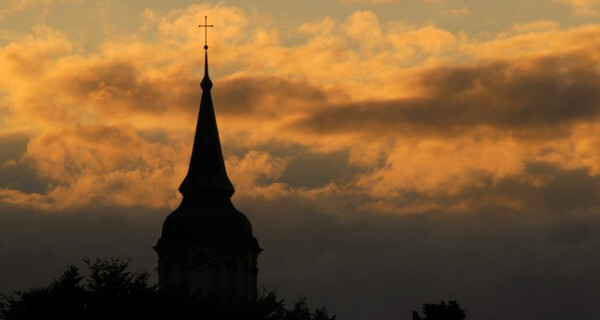Kirchturm Stadtpfarrkirche Sankt Barbara mit Sonnenuntergang im Hintergrund